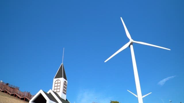 Model of a small chapel by the hillside with wind turbines