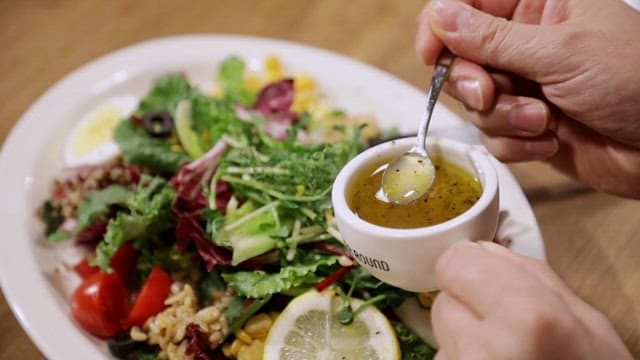 Fresh salad with dressing being poured