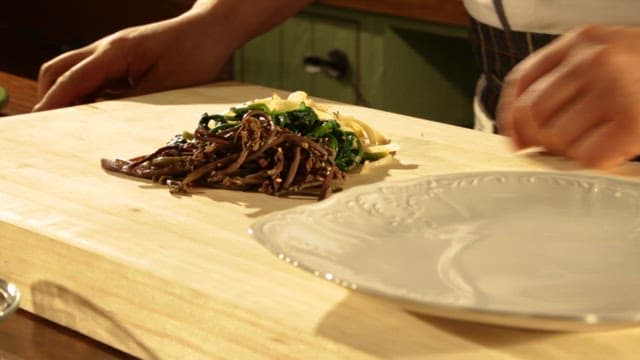Chopping Various Types of Greens on a Wooden Cutting Board