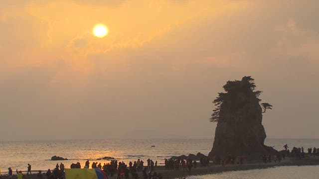 Vacationers Gathered at a Beach with Large Coastal Rocks