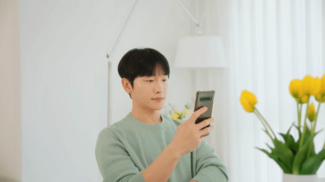 Man using a smartphone in a room with white interior