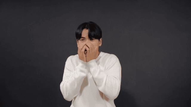 Man covering his mouth in surprise and expressing anxiety