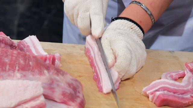 Person cutting fresh pork belly
