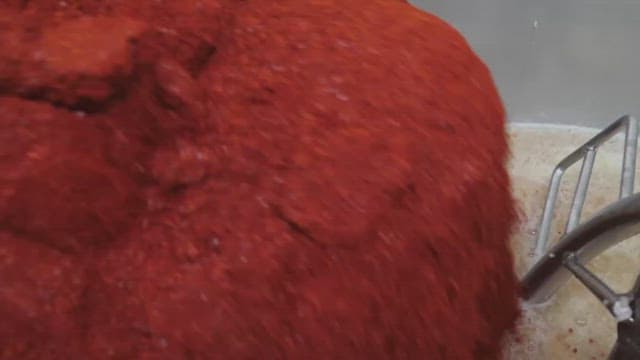 Mixing red pepper powder and other ingredients in a machine