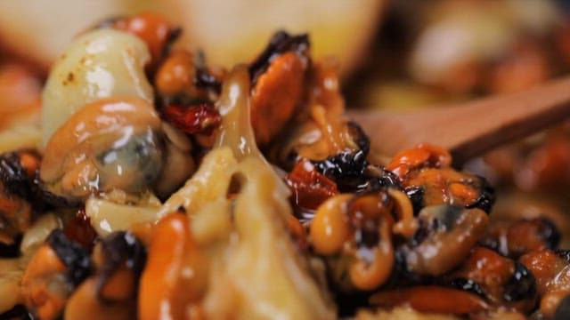 Spoonful of delicious and savory mussel gambas