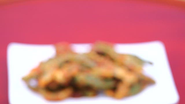 Steamed chili peppers, seasoned well and served on a white plate