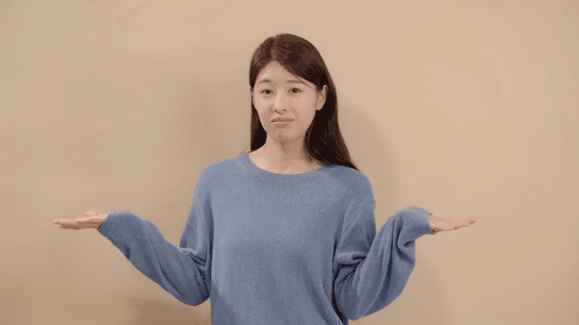 Long haired woman shrugging and sneering