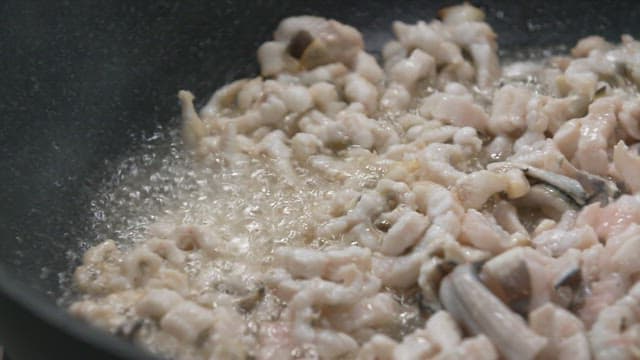 Cooking seafood in a frying pan with trimmed eel