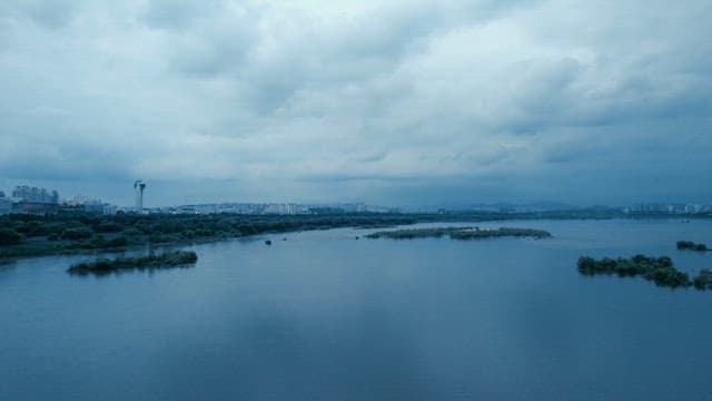 Calm river with a city skyline on a cloudy day