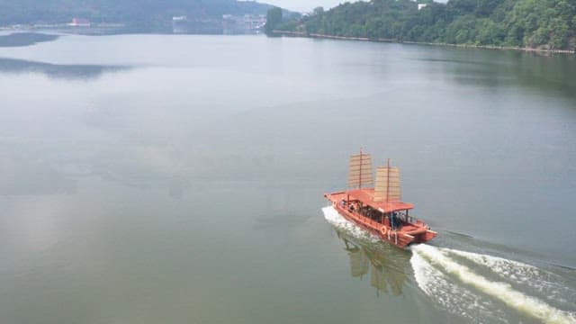 Traditional sailboat gliding on calm lake waters