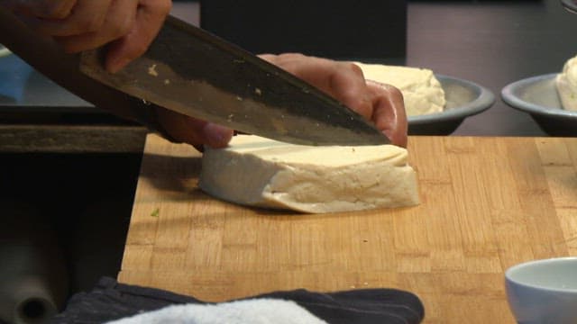 Cutting tofu on a wooden board