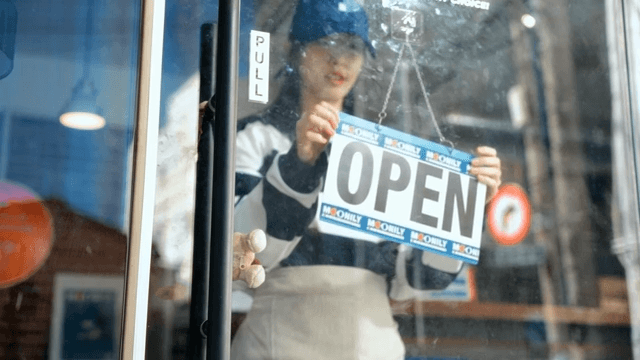 Woman turns pizza shop sign to announce open