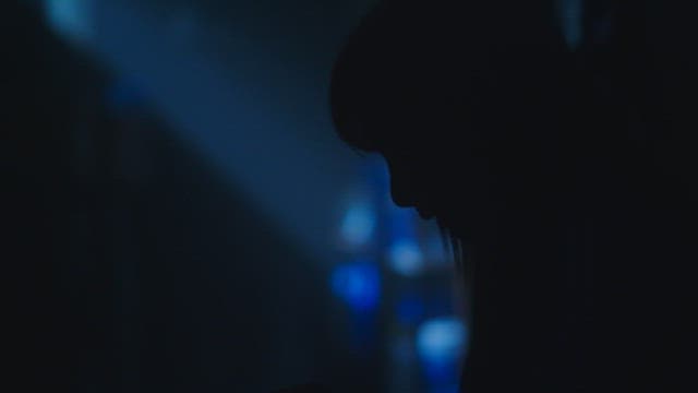 Woman crying in a dark room with blue light