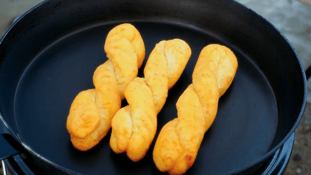 Placing fried bread twists on a pan