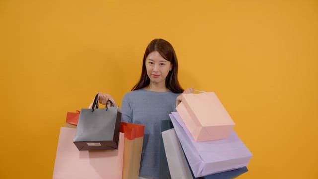 Long haired woman carrying many shopping bags and smiling