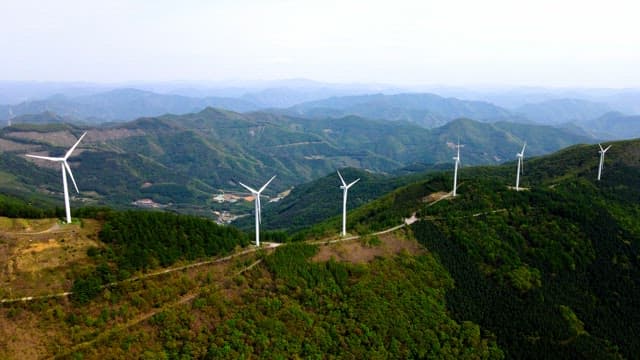 Wind turbines on a lush green mountain range