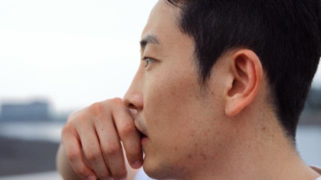 Man looking thoughtful by the water
