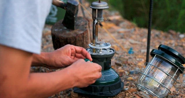 Man Igniting a Portable Gas Stove Outdoors