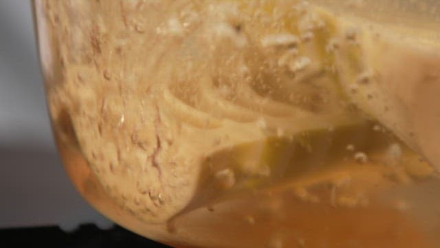 Bamboo shoots slowly boiling with bubbles in water in a pot