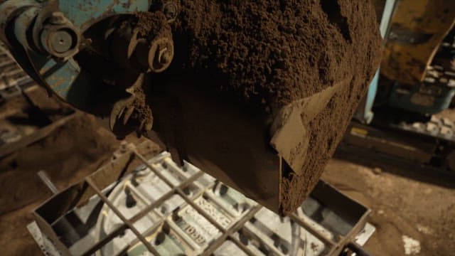 Excavator pouring soil at a site