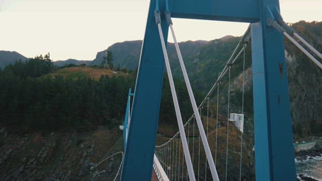 Blue suspension bridge over coastal cliffs
