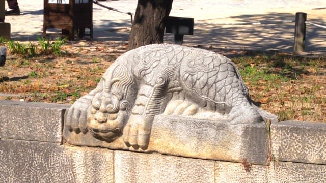 Stone lion statue in a park during daytime