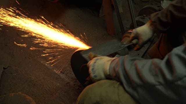 Worker sharpening a knife with sparks