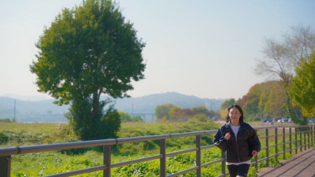 Woman jogging along a riverside path