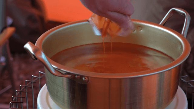 Putting ramen base into a nickel-silver pot filled with water