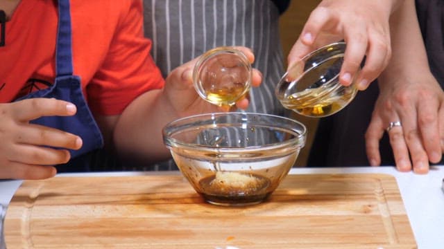 Adult and child making sauce together in the kitchen