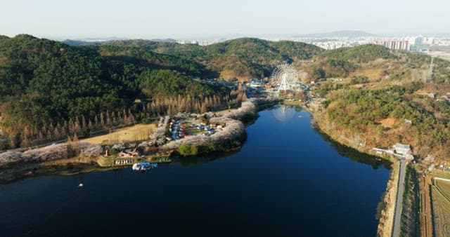 Amusement park near a lake surrounded by forests