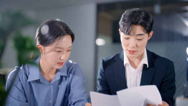 Two colleagues discussing documents