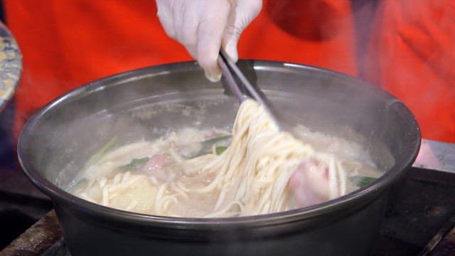 Noodles being served from a pot