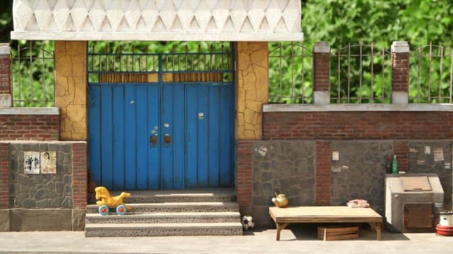 Large toy horse moving in front of a gate of old house