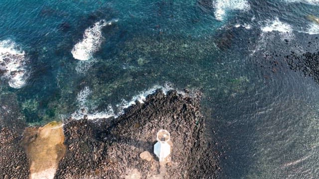 Lighthouse by the rocky seashore