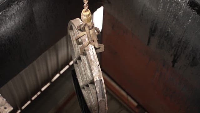 Metal part being dipped in liquid
