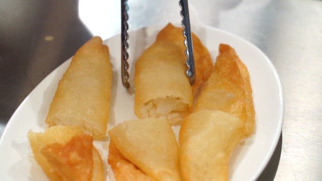 Fried dumplings being served on a plate