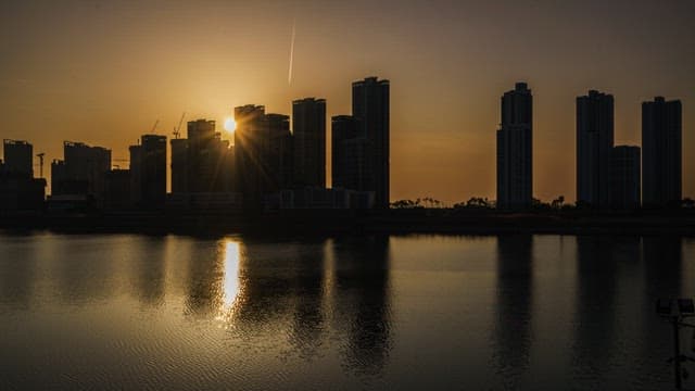 Sunset Reflections on City Skyline by Water
