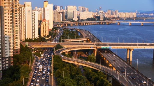 Roads and skyscrapers with river view during rush hour