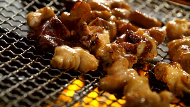 Grilling pork intestines on a grill