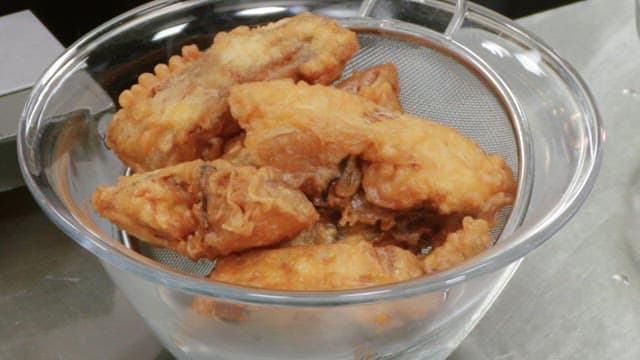 Close-up of fried fish pieces in a strainer