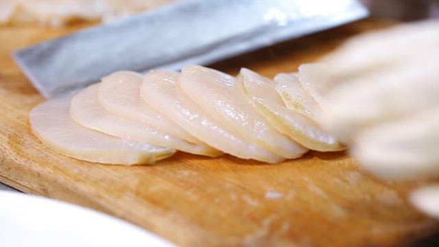 Sliced scallops on a cutting board