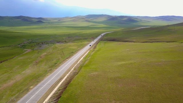 Long road through vast green fields