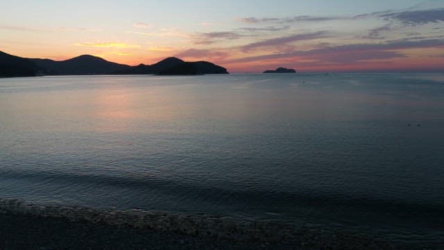 Serene Sunset over Calm Coastside with Distant Islands