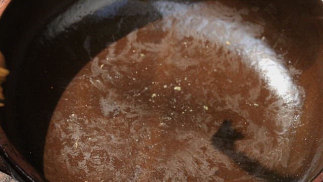 Plating fermented kimchi in a jar with hands wearing vinyl gloves