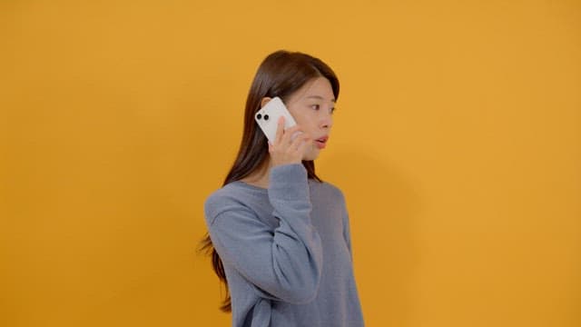 Side view of a long-haired woman talking on the phone
