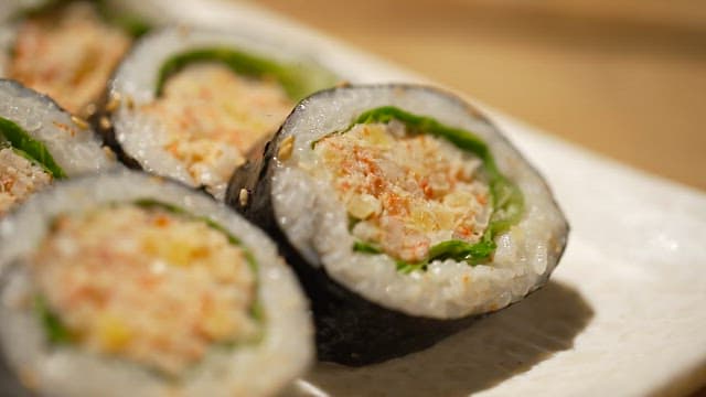 Delicious crab meat gimbap neatly plated on a white plate