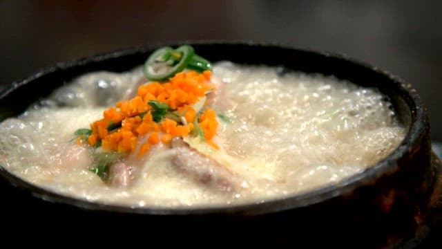 Boiling ginseng chicken soup with green onions and chopped carrots