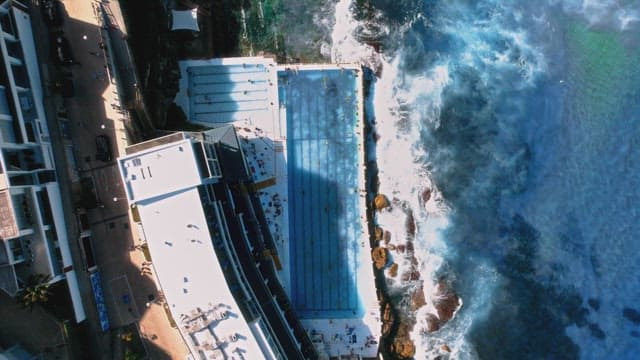Beach Swimming Pool Crowded with People Enjoying Water Activities