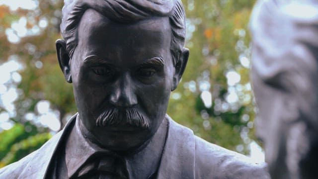 Statue of a man with a mustache in the park